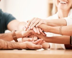 Team hands in support and unity with diversity group of businesspeople in meeting in office. Motiva